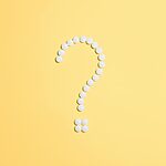 White pills arranged into a question mark shape on a vibrant yellow background.