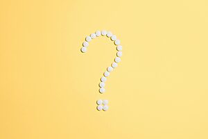10 passi per assemblare un PC? ATX 3.1 semplifica tutto 5 White pills arranged into a question mark shape on a vibrant yellow background.