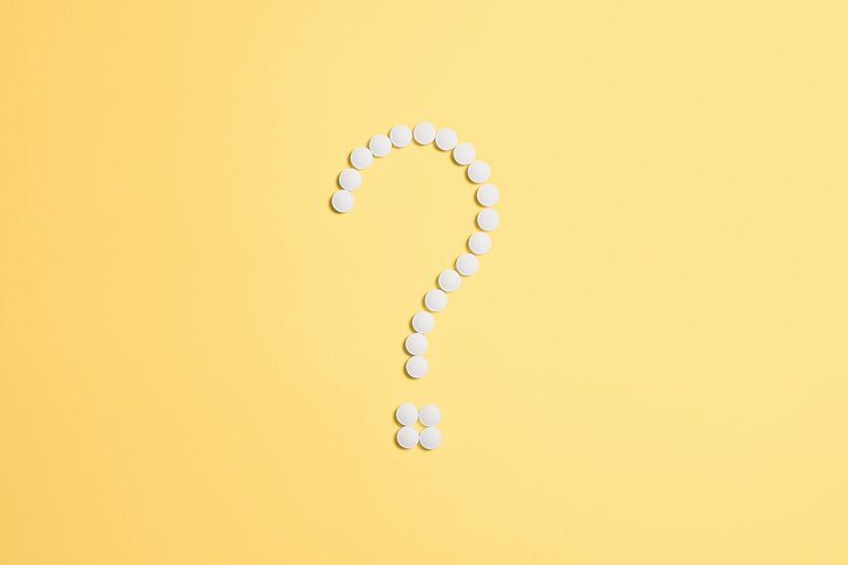 10 passi per assemblare un PC? ATX 3.1 semplifica tutto 5 White pills arranged into a question mark shape on a vibrant yellow background.
